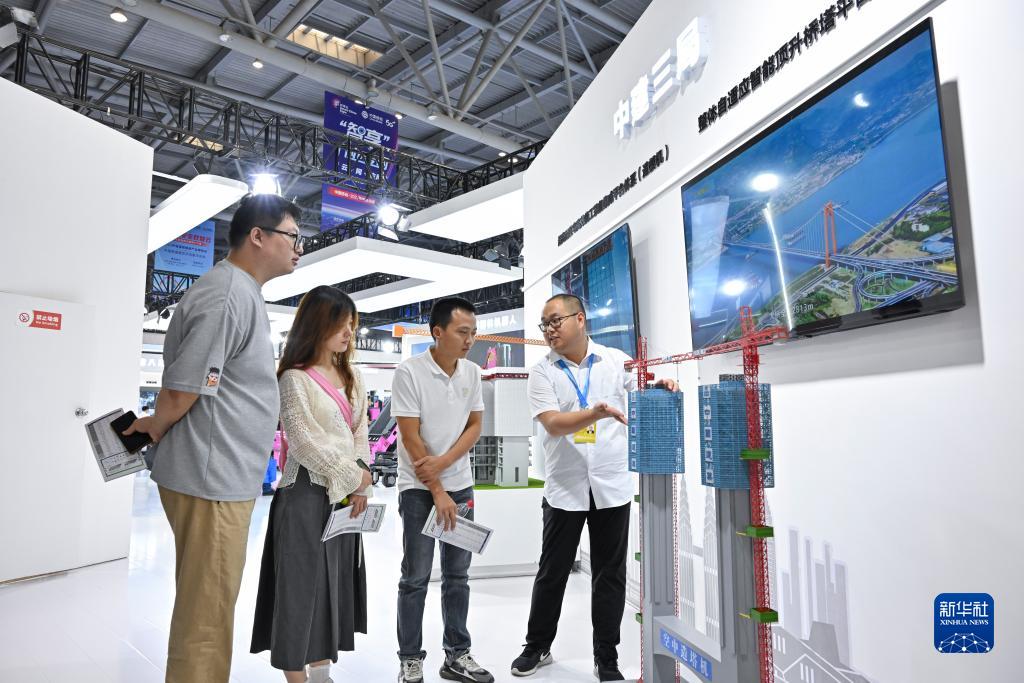 9月4日，觀眾在智博會(huì)上參觀中建三局展示的空中造塔機(jī)。新華社記者 王全超 攝