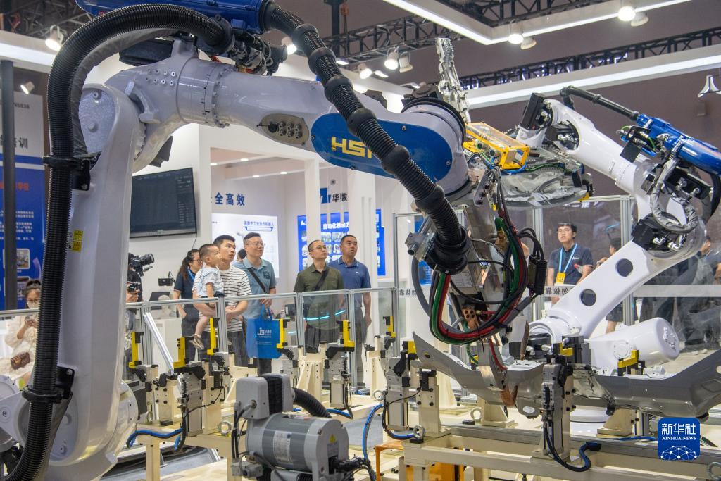 9月4日，在2023智博會(huì)華數(shù)機(jī)器人展廳，嘉賓參觀機(jī)器人工作設(shè)備。新華社記者 唐奕 攝